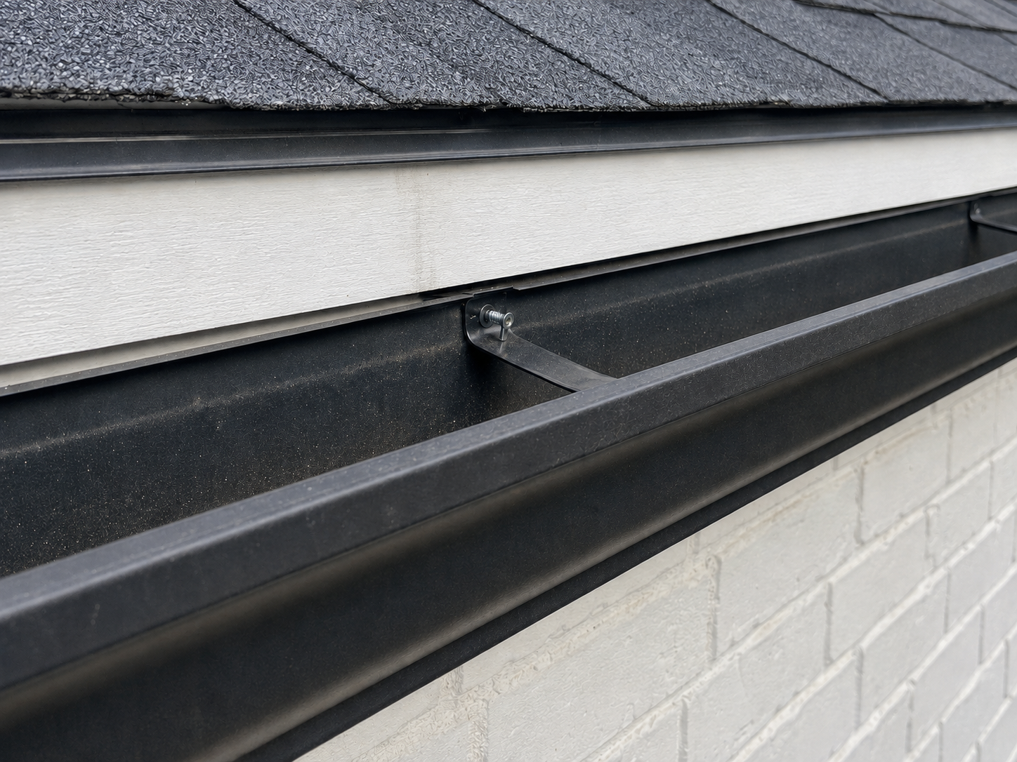 Black gutter beginning to pull away from the fascia at a loose attachment point